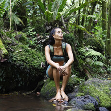 Femme pensive en pleine nature les pieds dans l'eau - AOA Polynesian Forests